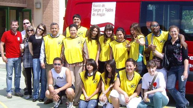 Las manos que ayudan junto a la furgoneta de la Asociación de Donantes de Sangre de Aragón.